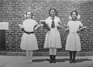 These girls demonstrate the healthy practice of carrying equal weight in each arm to avoid distorting the spine. 1913
