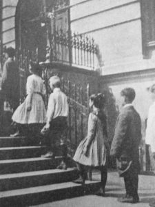 School children being evaluated for posture flaws while walking up stairs. 1913.